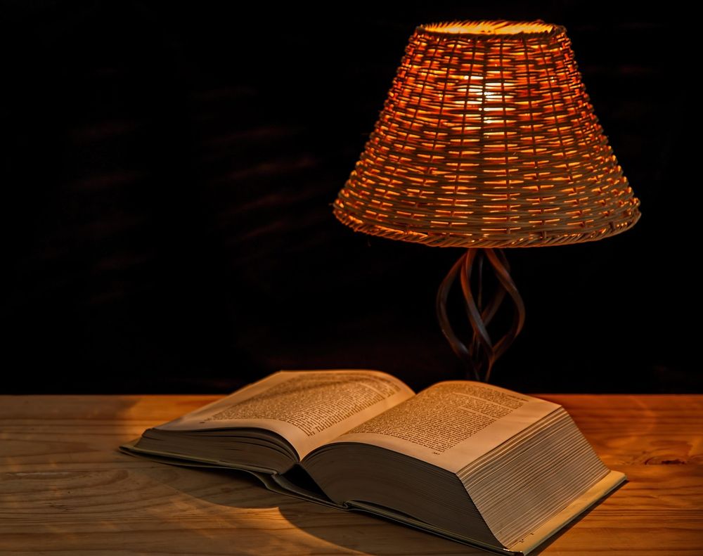 Rattan table lamp glowing over an open book